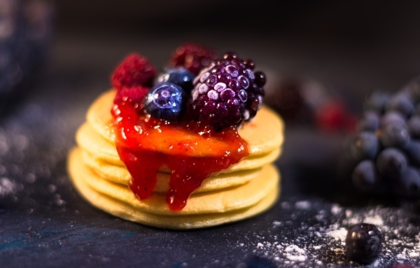 Оладьи с джемом и ягодами на столе