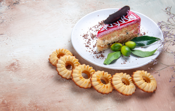 Кусок торта на столе с песочным печеньем