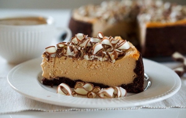 Кусок торта с шоколадной стружкой на белой тарелке