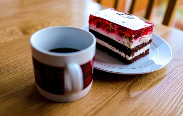 Кусок торта с чашкой кофе на деревянном столе
