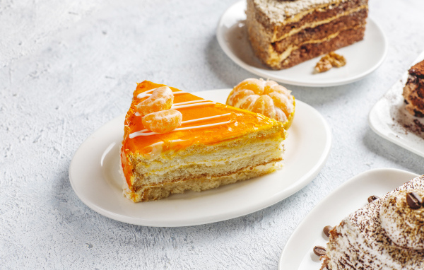 Кусок торта с мандарином на белой тарелке