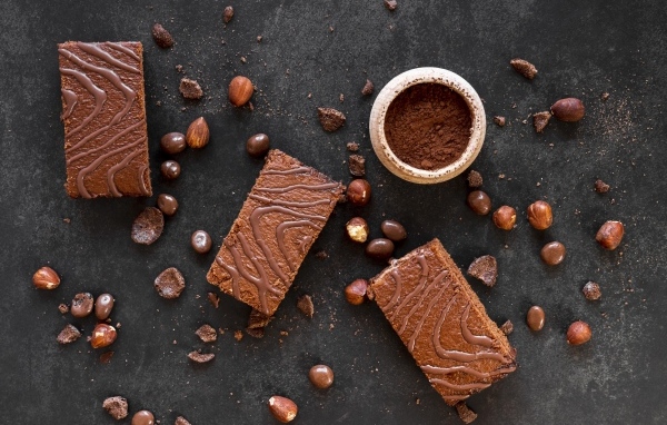 Кусочки пирожных на сером столе с шоколадными зернами