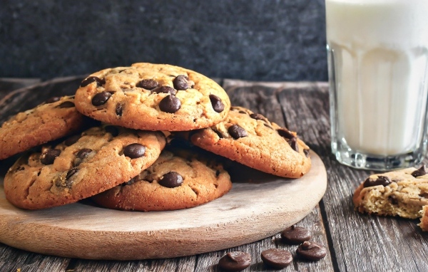 Круглое печенье с шоколадом на столе со стаканом молока