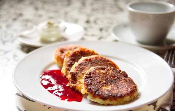 Румяные сырники на тарелке с джемом на завтрак