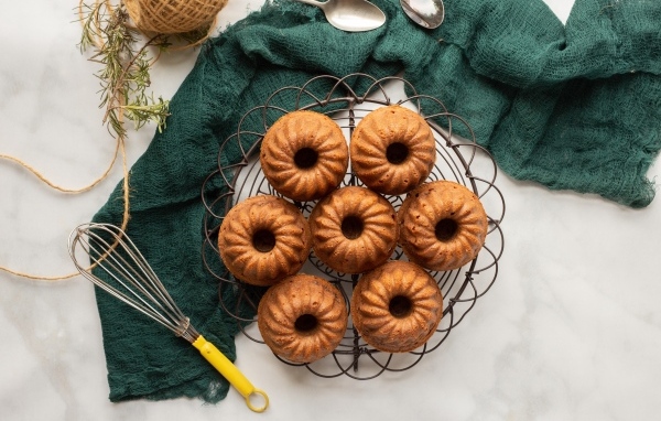 Сладкие вкусные кексы на столе с тканью