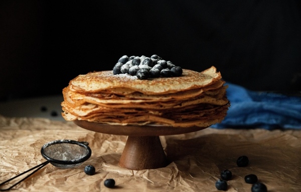 Тонкие сладкие блинчики с ягодами черники и сахарной пудрой