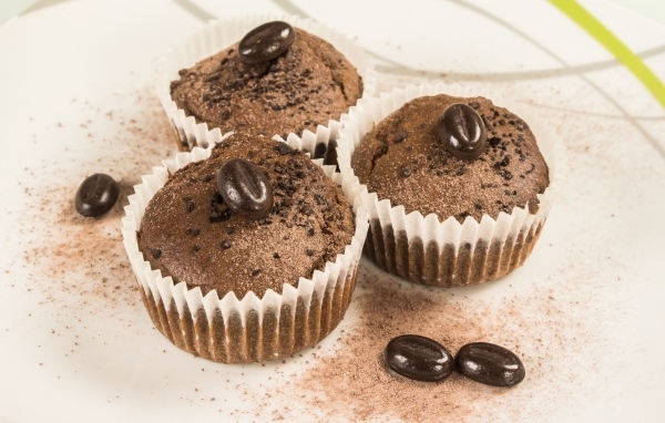 Three chocolate cupcakes with coffee beans