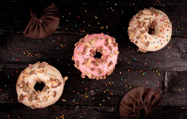 Три сладких пончика на черном столе