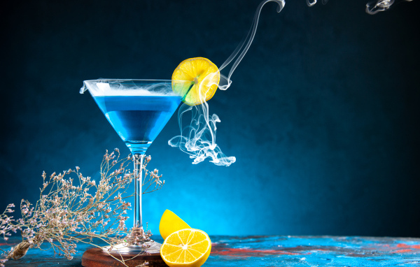 Голубой коктейль с лимоном на столе