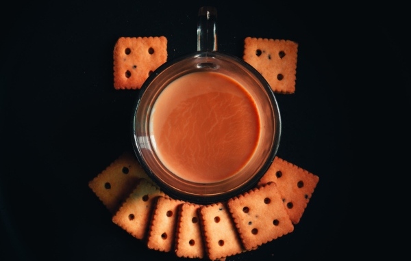 Чашка какао с печеньем на черном фоне