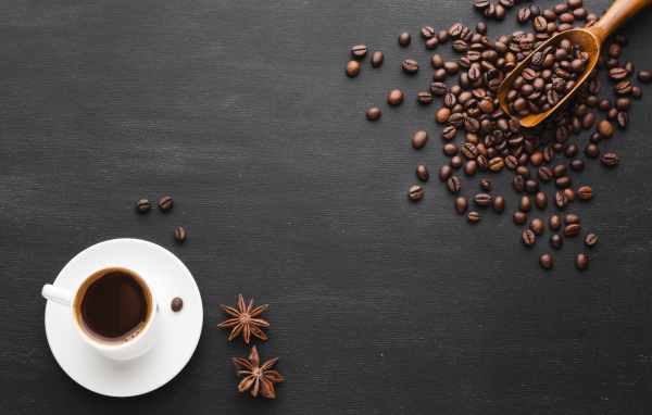 Чашка кофе на черном столе с зернами