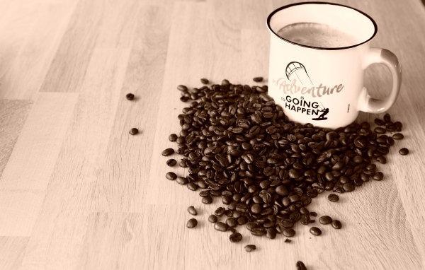 Чашка кофе на деревянном столе с кофейными зернами