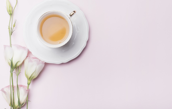 Чашка чая на розовом фоне с цветами эустомы