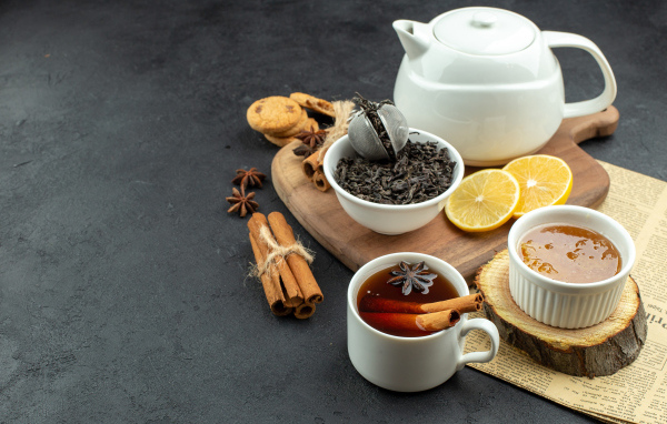 Вкусный чай на столе с лимоном и пряностями