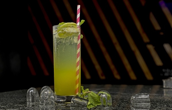 Зеленый коктейль мохито в высоком стакане со льдом
