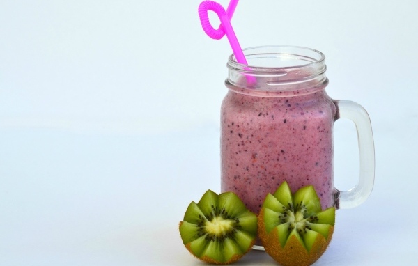 Розовый ягодный смузи на столе с киви