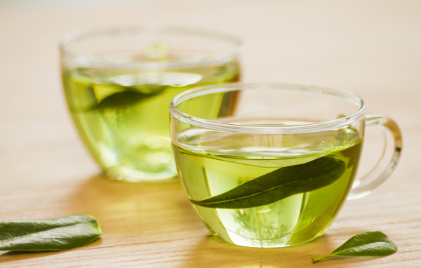 Две кружки зеленого чая с листьями