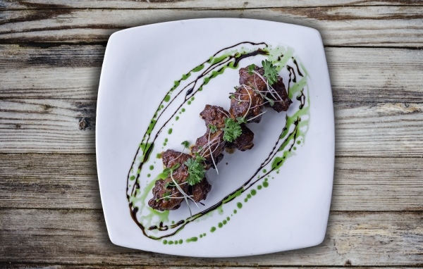 Шашлык из свинины на тарелке на деревянном столе