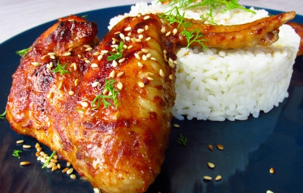 Рис на тарелке с жареным куриным крылом