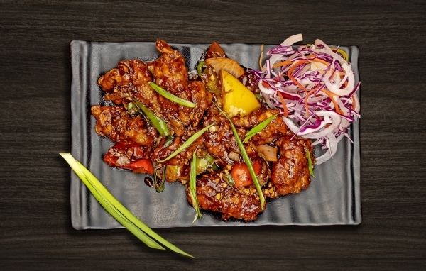 Острые куриные крылышки с салатом на тарелке