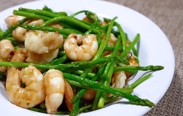 Спаржа с креветками в белой тарелке