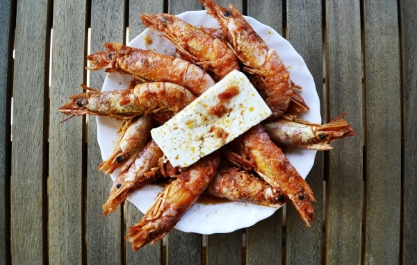 Жареные креветки на тарелке с сыром