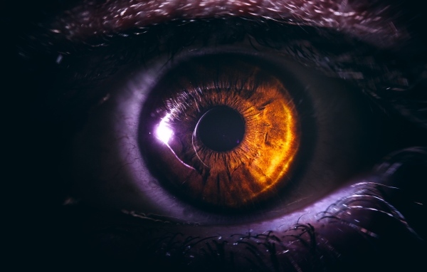 Черный зрачок карего глаза крупным планом