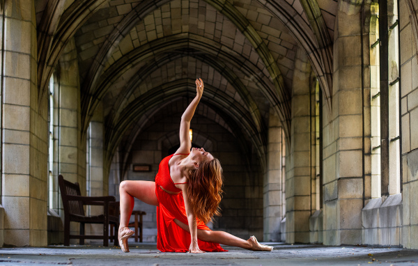 Девушка в красном наряде танцует в здании