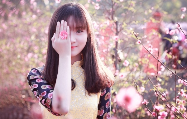 Девушка азиатка закрыла глаз рукой