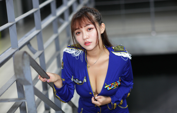 Девушка азиатка в форме стоит на ступеньках