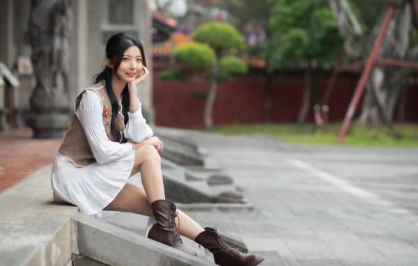 Азиатка сидит на холодных ступеньках