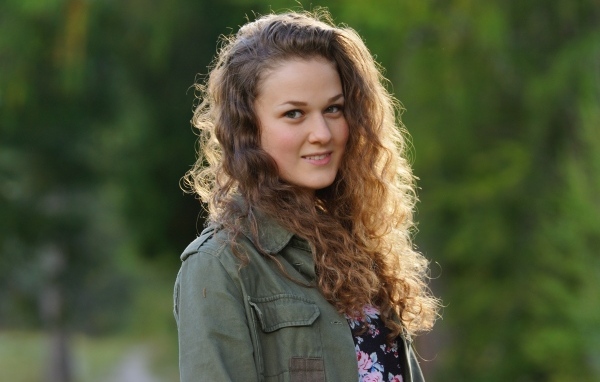 Красивая девушка с кудрявыми волосами в лучах солнца