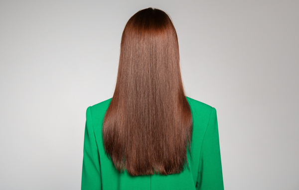 Красивые волосы девушки в зеленом пиджаке