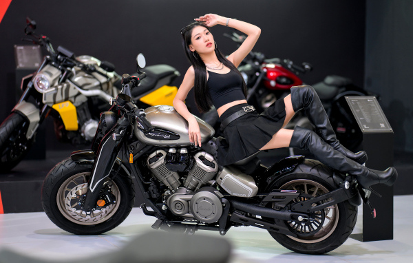 Брюнетка азиатка лежит на мотоцикле