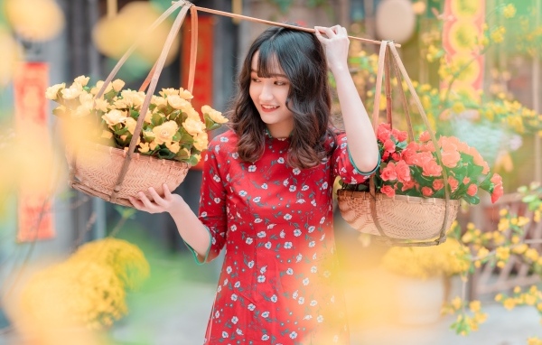 Милая девушка азиатка с цветами в красном платье