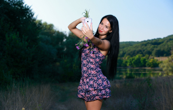 Милая брюнетка в коротком платье делает фото