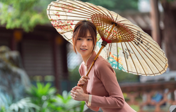 Милая улыбающаяся азиатка с зонтом