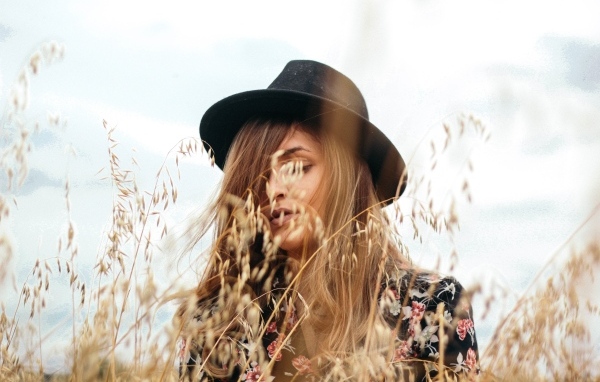 Девушка в черной шляпе в траве