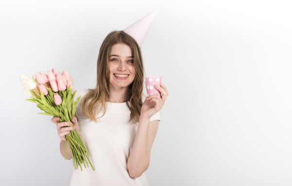 Счастливая девушка с букетом тюльпанов и подарком на день рождения