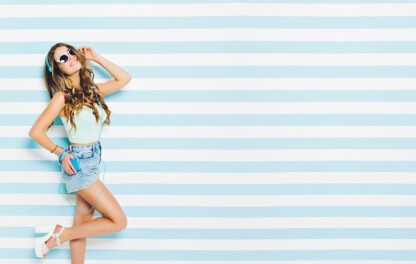 Современная девушка в очках на полосатом фоне