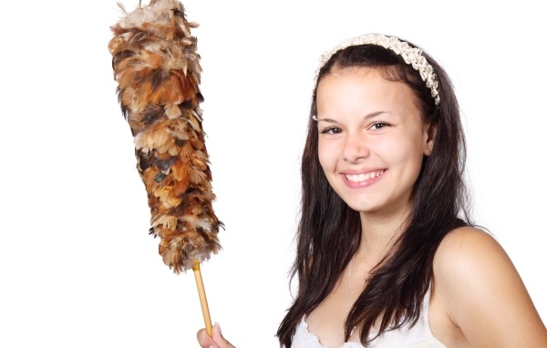 Улыбающаяся девушка убирается в комнате