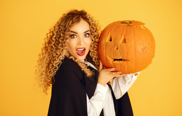 Удивленная девушка с тыквой на Хэллоуин