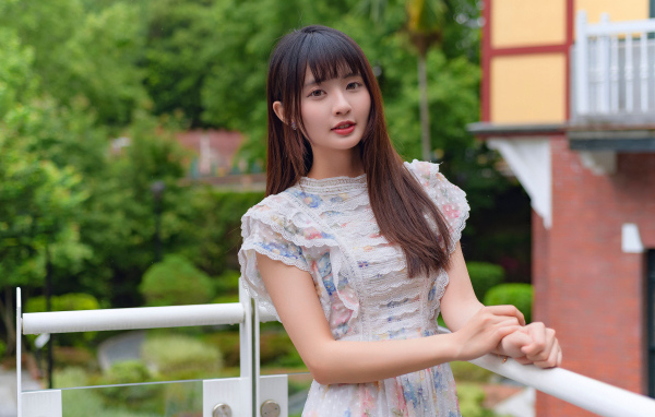 Нежный взгляд молодой длинноволосой азиатки в платье