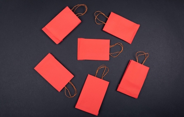 Красные пакетики для подарков на черном столе