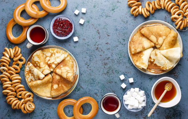 Тонкие блинчики, бублики и джем на столе на Масленицу