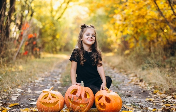 Девочка с тыквой в парке на праздник Хэллоуин