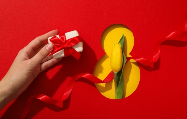 Красный фон с подарком, желтым тюльпаном и цифрой на 8 марта