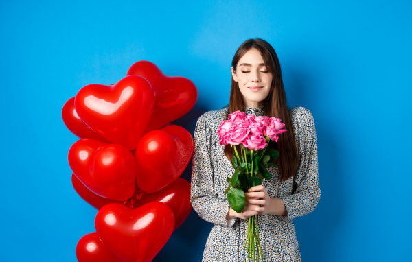 Девушка с букетом роз и воздушными шарами на день Влюбленных