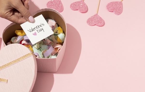 Коробка в форме сердца на розовом фоне на День Святого Валентина