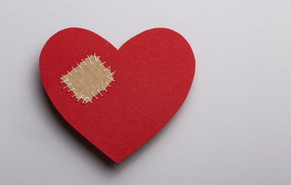 Большое красное сердце с заплаткой на сером фоне